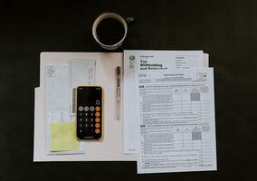 un bureau avec une calculatrice et des fichiers comptables