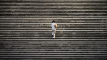 une femme montant des marches sur un très large escalier